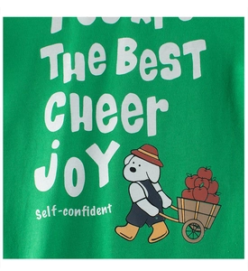 Détail d'un t-shirt en coton vert avec imprimé de chien de dessin animé mignon