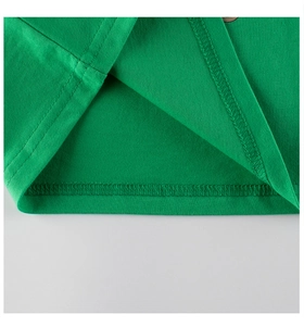 Détail de l'ourlet en coton vert gazon avec des surpiqûres à double aiguille de qualité