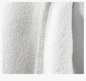 Gros plan sur tissu polaire blanc montrant les coutures des bords et la texture