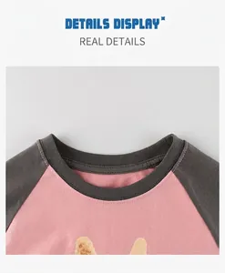 Détail du col raglan rose et gris anthracite avec coutures soignées sur un t-shirt enfant