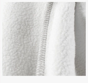 Detailed macro view of soft white fleece fabric texture and high-quality overlock stitching