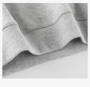 Detail shot of the ribbed hem and stitching on a grey cotton knitted kid's sweatshirt