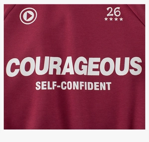 Close-up of courageous letter print on burgundy red fleece sweatshirt for boys