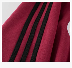 Close-up of burgundy sweatshirt featuring black side stripes and soft fleece texture
