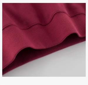 Detail of the ribbed cuff and hem on the dark red boys' cotton sweatshirt sweater