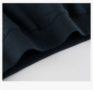 Detailed macro view of the ribbed hem and premium cotton fabric on navy sweatshirt