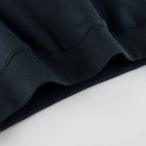 Close-up of navy blue knit sweatshirt showing high-quality ribbed cuffs and stitching