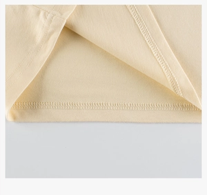 Detailed close-up showing double-needle stitching on cream knitted cotton t-shirt hem