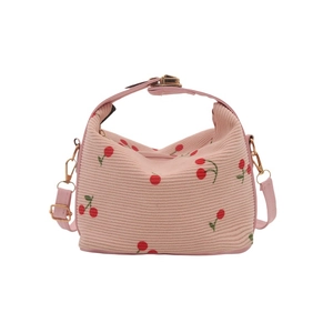 Pink shell bag with cherry print, featuring a top handle and adjustable shoulder strap