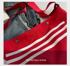 Gros plan d'un sac en toile rouge avec rayures blanches et détails en métal noir chic