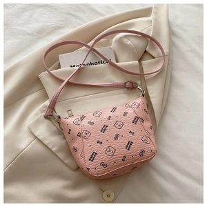 Detailed view of pink luxury bucket bag with cartoon bear print on beige blazer background