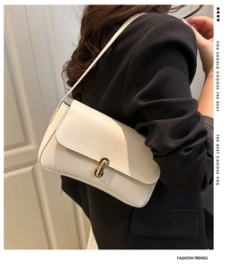 Close-up of cream-white rectangle shoulder bag with elegant golden U-shaped rotating lock