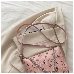 Detailed view of pink bucket bag with bear print, lychee texture, and silver chain strap