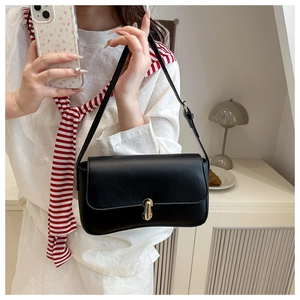 Close-up of black matte faux leather handbag featuring a golden rectangular twist lock