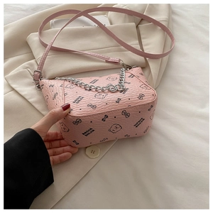Close-up of pink bucket bag with cartoon bear prints and silver chain strap detail