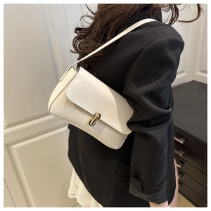 Close-up of minimalist white leather shoulder bag featuring a sleek gold metal buckle