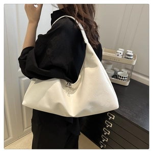 Close-up of white hobo bag with wrinkled texture and metal zipper detail on shoulder