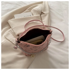 Detail of pink bucket bag with cartoon print showing interior capacity and chain strap