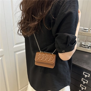 Brown quilted mini crossbody bag with gold chain strap shown on model from back view