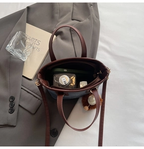 Blue denim and brown leather bucket bag showing interior space for phone and makeup