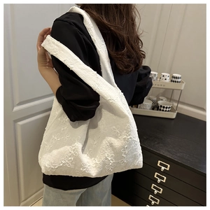 Detailed texture of white lace flower embroidery on a summer canvas tote bag for women