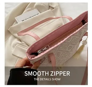 Detail of elegant geometric jacquard tote bag with smooth zipper and tassel pendant