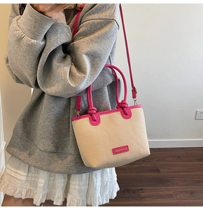 Detail der Kontrast-Tasche mit rosa Ledergriffen und gewebter Stoffoberfläche
