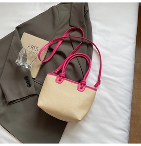 Détail du sac en paille tressée avec bordure en cuir rose vif et bandoulière réglable