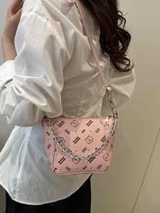 Pink bucket crossbody bag with letter print and metal chain on a minimalist model