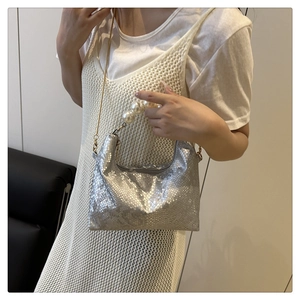 Detail of silver snake-pattern bag featuring large pearl handle and gold chain strap