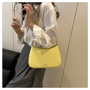 Détail d'un sac à bandoulière en similicuir jaune avec inscription FASHION en noir