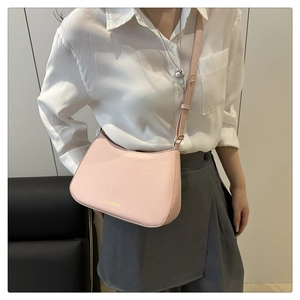 Détail du sac demi-lune rose clair avec lettrage doré et bandoulière réglable