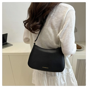 Detailaufnahme einer schwarzen Halbmond-Schultertasche mit goldenem FASHION-Schriftzug