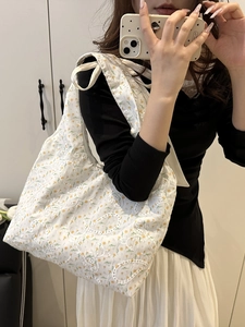 White lace tote bag with yellow floral embroidery and ribbon bow on the shoulder strap