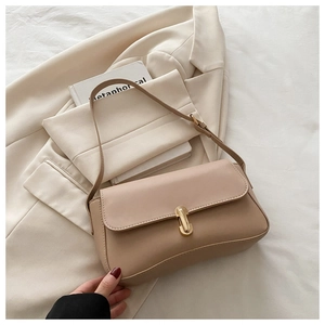 Close-up of beige PU leather shoulder bag with a sleek gold metal twist lock buckle