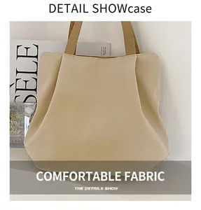 Détail du sac cabas en toile crème montrant le design plissé et le tissu texturé