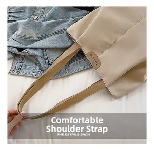 Gros plan des bandoulières confortables et de l'étiquette en cuir sur le sac en toile