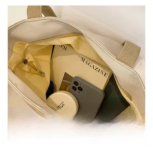 Vue intérieure du grand sac cabas en toile beige avec magazine et articles du quotidien