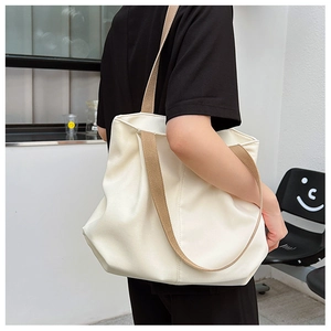 Vue latérale du grand sac cabas beige avec large bandoulière en tissu kaki et style épuré