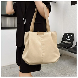 Gros plan du grand sac cabas beige avec logo en cuir et détails en nylon durable