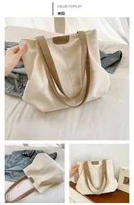 Détail du grand sac cabas en toile blanc cassé avec anses marron et logo en cuir