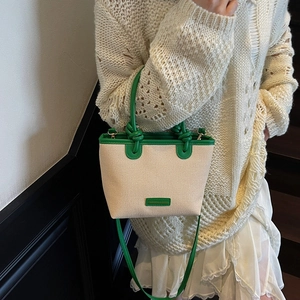 Elegant cream woven tote bag with vibrant green trim and detachable shoulder strap