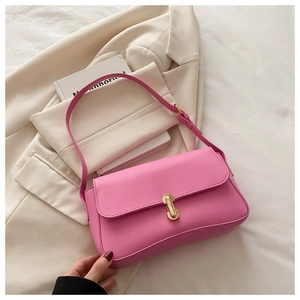 Detail of rose pink leather handbag with gold bar metal clasp and adjustable shoulder strap