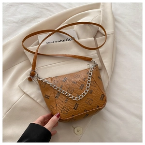 Détail du sac seau marron à motif litchi avec imprimé ours et bandoulière chaîne argentée