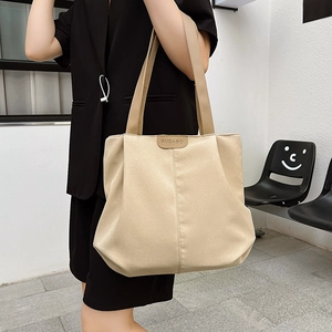 Sac fourre-tout minimaliste en toile beige avec poignées en PU porté par un mannequin