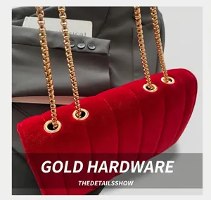 Detail of red quilted velvet shoulder bag with premium gold chain strap attachment