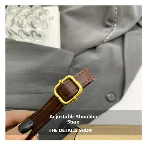 Détail de la bandoulière réglable en cuir marron avec boucle dorée et coutures précises