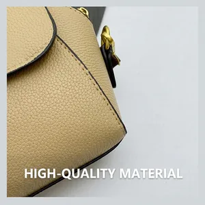 Détails de la couture du cuir beige grainé et de la chaîne dorée du sac à main