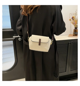 Vue arrière d'un sac bandoulière chic en cuir crème porté par un mannequin en intérieur