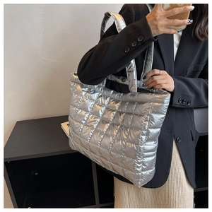 Close-up of a silver puffer tote bag with quilted details and metallic finish fabric